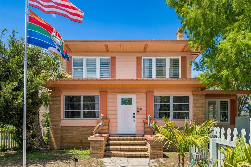 A two-story house with a peach exterior, a front porch, and a white picket fence — 4621 9TH AVENUE N, ST PETERSBURG, FL
