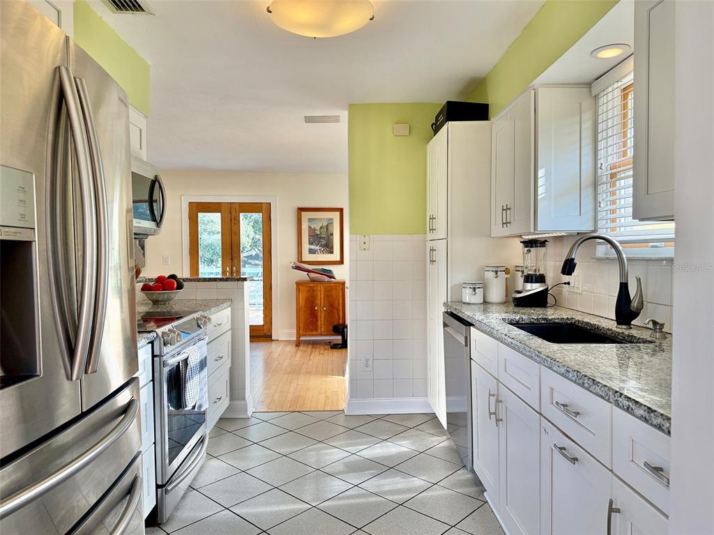 A staircase with wooden steps, a round window, and a modern pendant light fixture — 237 20TH AVENUE SE, ST PETERSBURG, FL