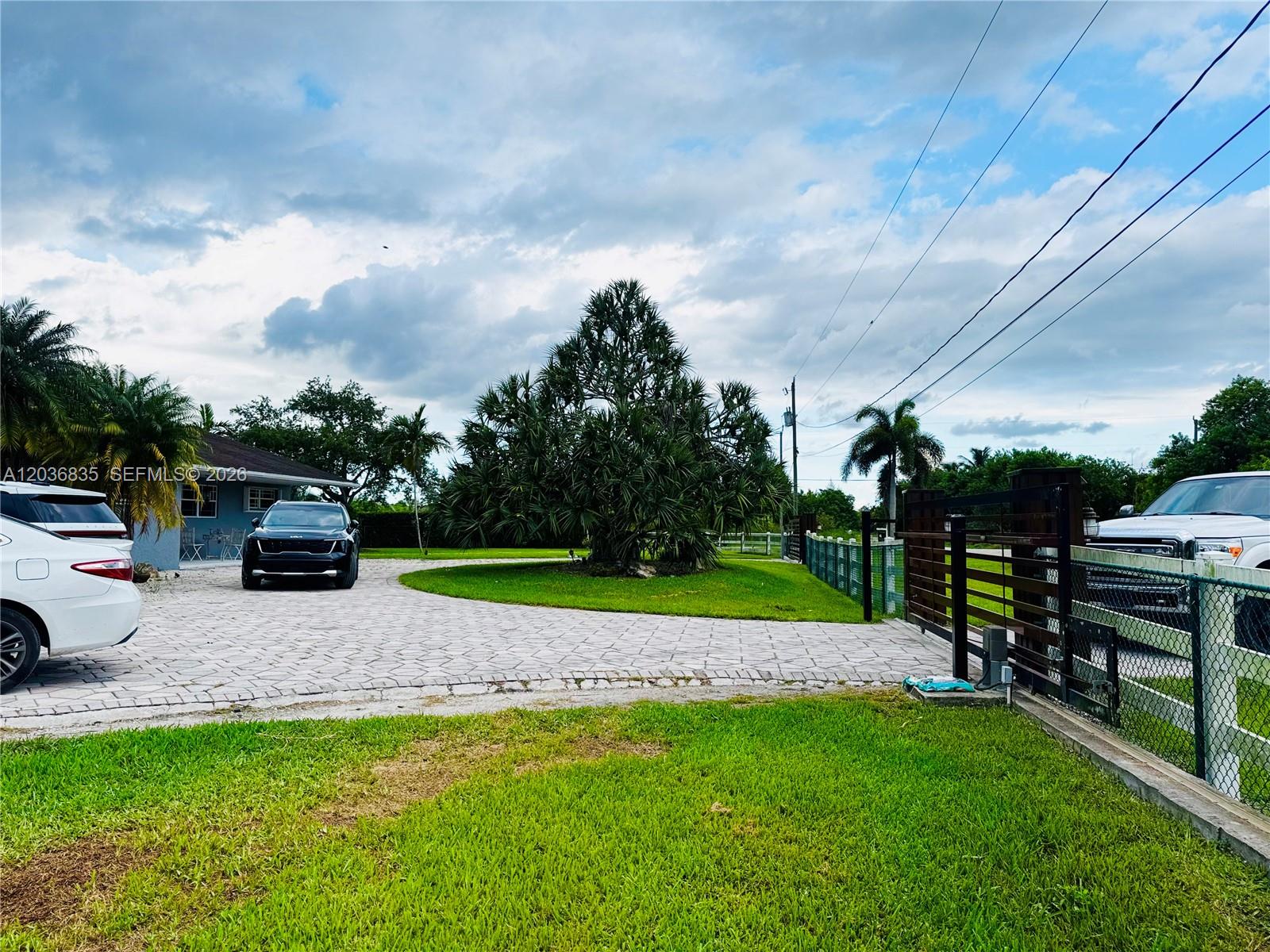 A paved driveway leads to a house with a large tree and a gated entrance — 21217 SW 160 ST, Miami FL 33187, MIAMI, FL