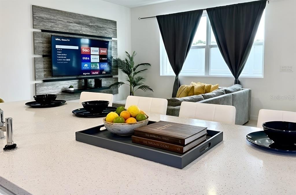 A living room features yellow armchairs, a wall-mounted television, and a coffee table — 835 LONGBOAT DRIVE, DAVENPORT, FL