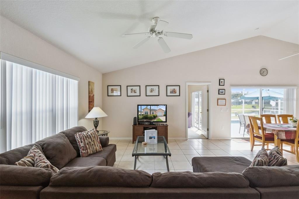 A living room with a brown sectional sofa, tile flooring, and a sliding glass door — 621 RESERVE DRIVE, DAVENPORT, FL