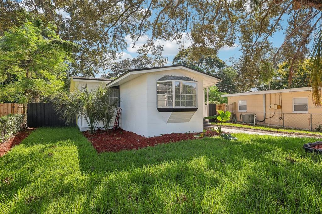 A white house with a bay window and a green lawn under large oak trees — 1815 LARKIN AVENUE, ORLANDO, FL