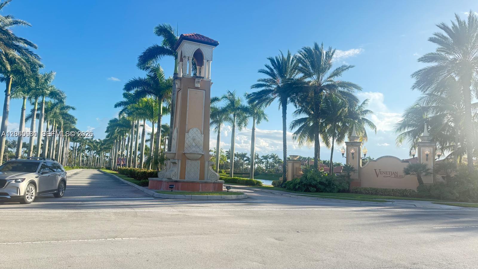 A tall decorative tower stands at the entrance of a community with palm trees — 15201 SW 30th Ter, Miami FL 33185, MIAMI, FL