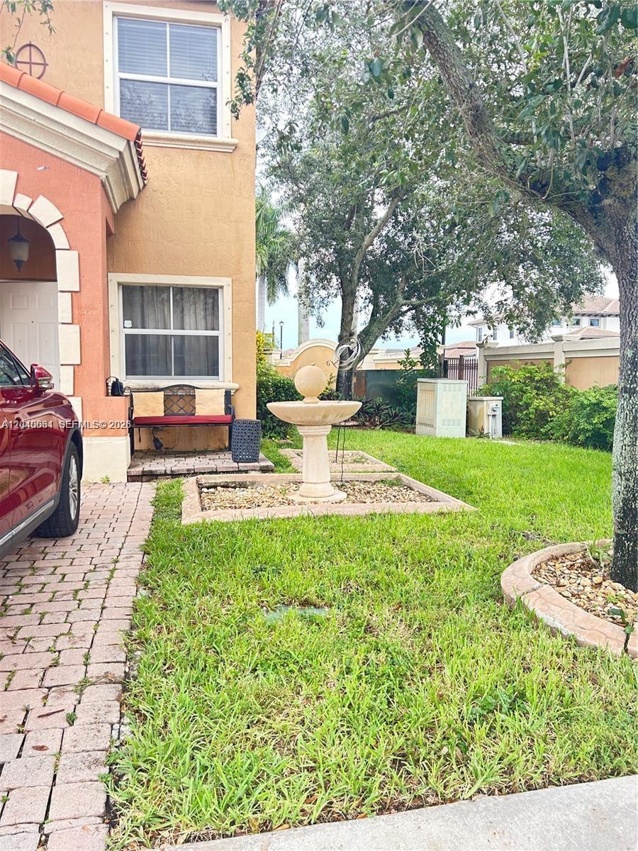 A stone fountain sits in the front yard of a two-story stucco house — 15201 SW 30th Ter, Miami FL 33185, MIAMI, FL