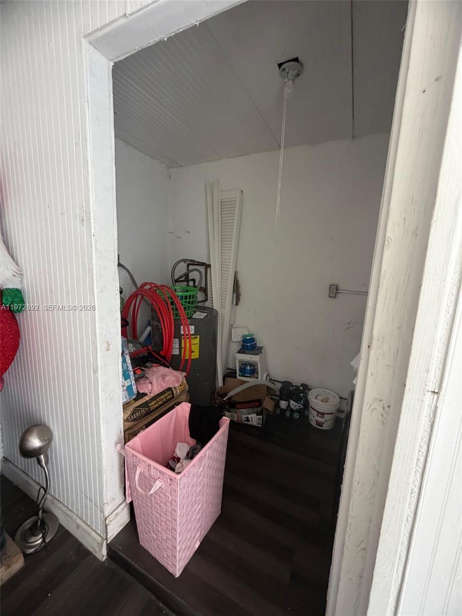 A small utility closet contains a water heater, laundry basket, and various stored household items — 331 NW 39th Ave # 1, Lauderhill FL 33311, LAUDERHILL, FL