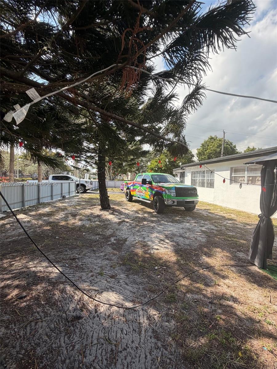 A colorful Ford pickup truck is parked in a sandy yard next to a house — 331 NW 39th Ave # 1, Lauderhill FL 33311, LAUDERHILL, FL