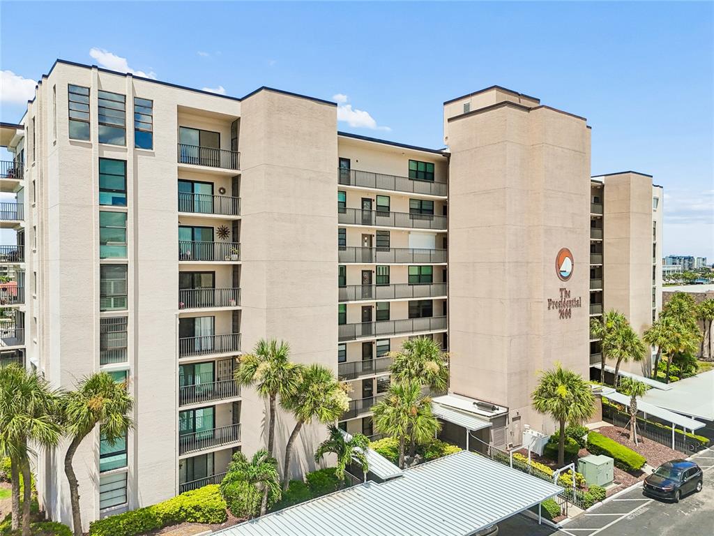 A multi-story beige apartment building features balconies and a covered parking area — 7600 SUN ISLAND DRIVE S UNIT 603, SOUTH PASADENA, FL