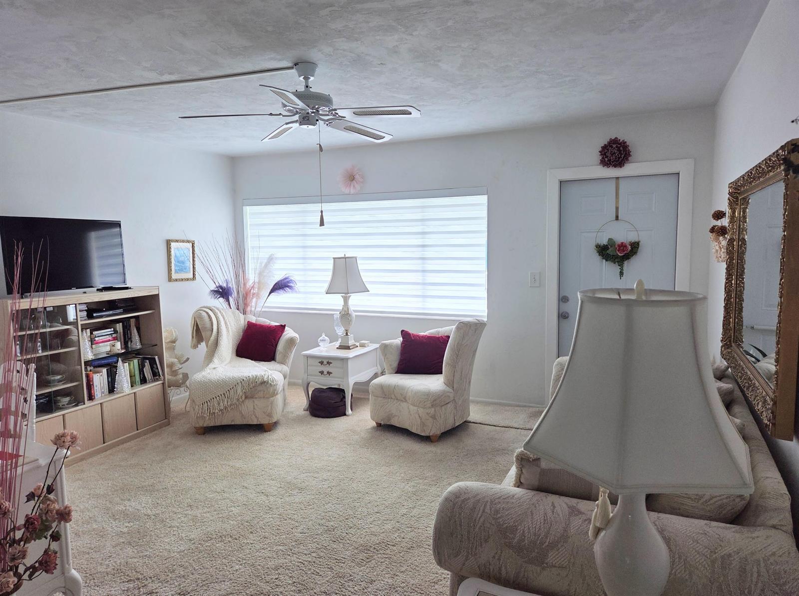 A living room features two armchairs, a bookshelf, a ceiling fan, and a front door — 2180 Lake Osborne Drive # 7, FL 33461, FL