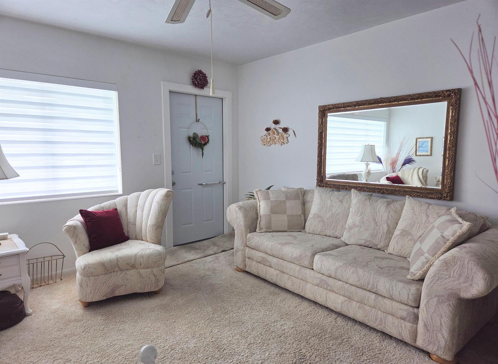 A living room features a patterned sofa, a matching armchair, a large mirror, and carpet — 2180 Lake Osborne Drive # 7, FL 33461, FL