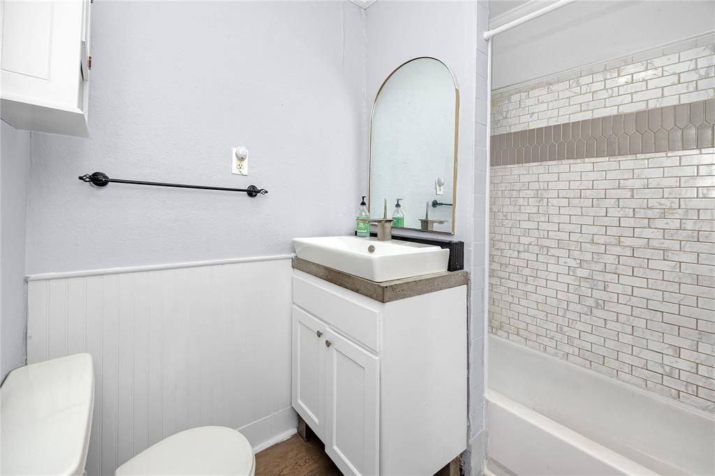 A bathroom features a white vanity with a vessel sink, an arched mirror, and a tub — 1763 PRESTON STREET S, ST PETERSBURG, FL