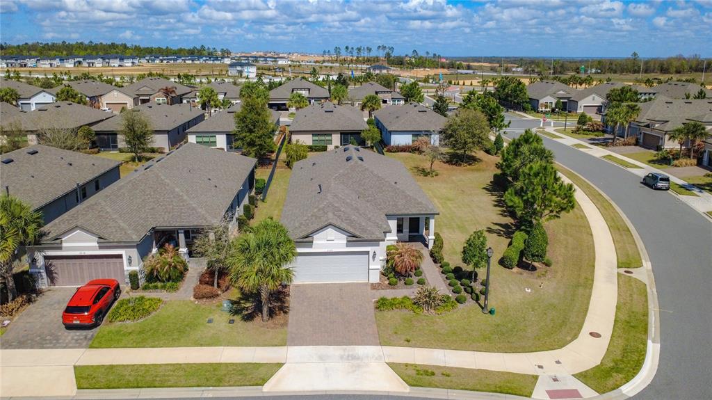 A paved entryway features a dark brown front door, a tall arched window, and stucco walls — 2330 HAMILTON RIDGE ROAD, CLERMONT, FL