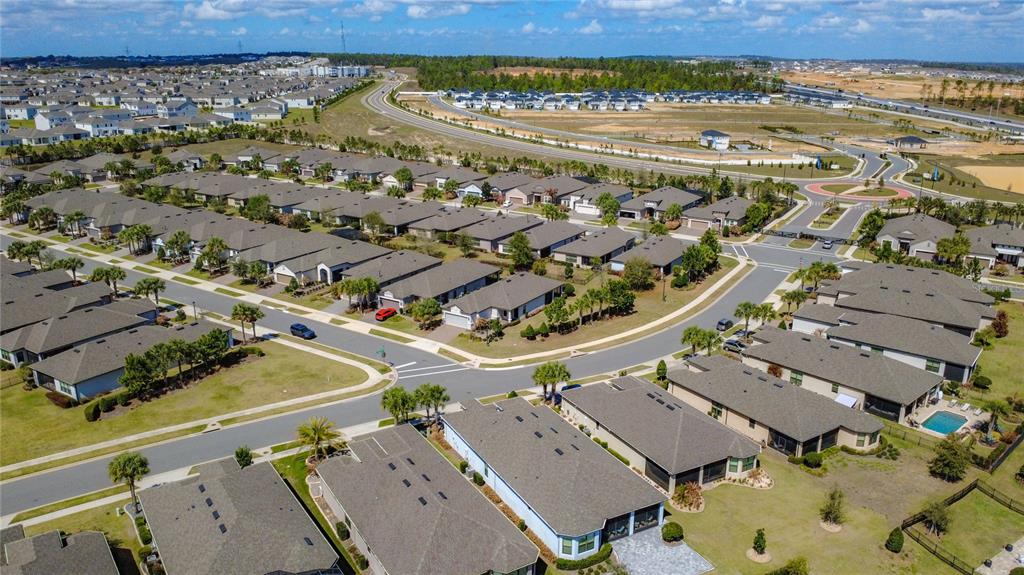 A living room with a bar area, tile flooring, and an open view into the kitchen — 2330 HAMILTON RIDGE ROAD, CLERMONT, FL