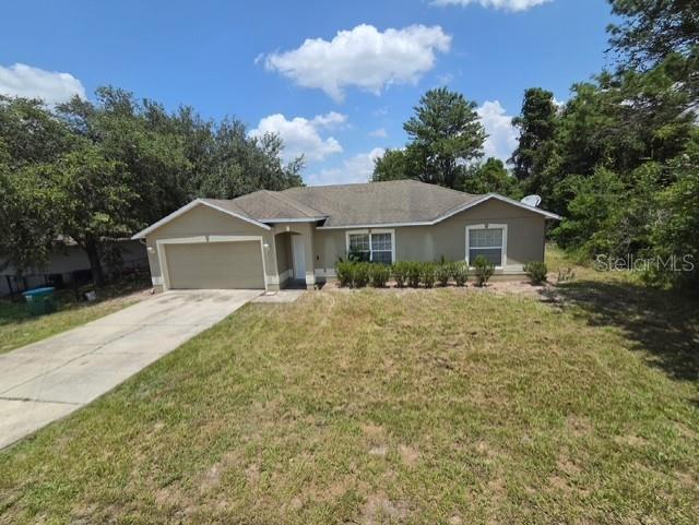 A single-story house with a beige exterior, a two-car garage, and a concrete driveway — 2149 N NORMANDY BOULEVARD, DELTONA, FL