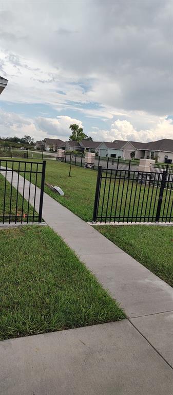 A stone and stucco pillar with a lantern sits in a landscaped front yard — 524 CENTRAL RIDGE LANE, FROSTPROOF, FL