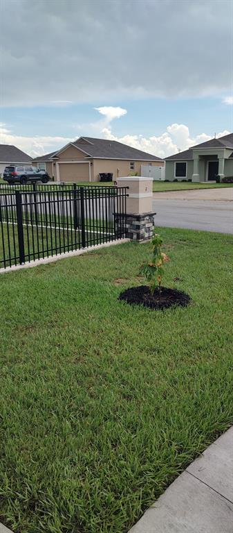 A covered patio features paver flooring, a porch swing, a ceiling fan, and stone accents — 524 CENTRAL RIDGE LANE, FROSTPROOF, FL
