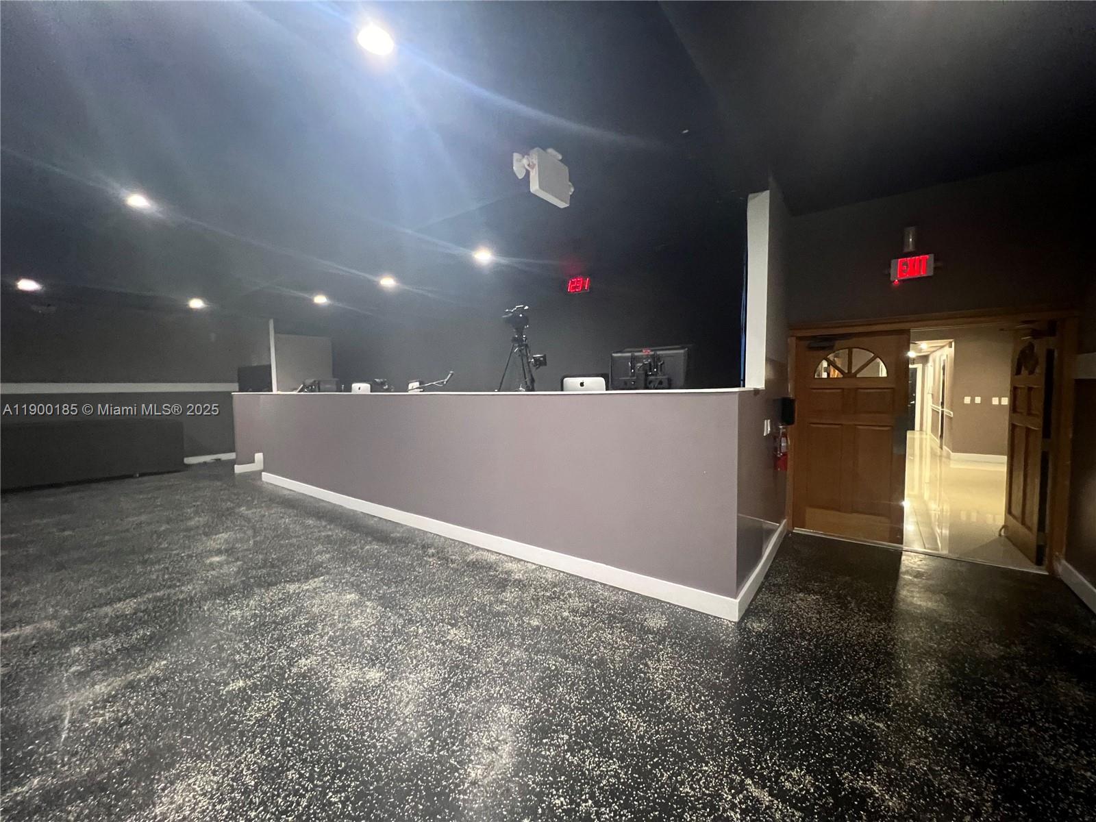 A commercial space features a dark reception desk, black speckled flooring, and an open doorway — 3800 N University Dr # 3846, Sunrise FL 33351, SUNRISE, FL