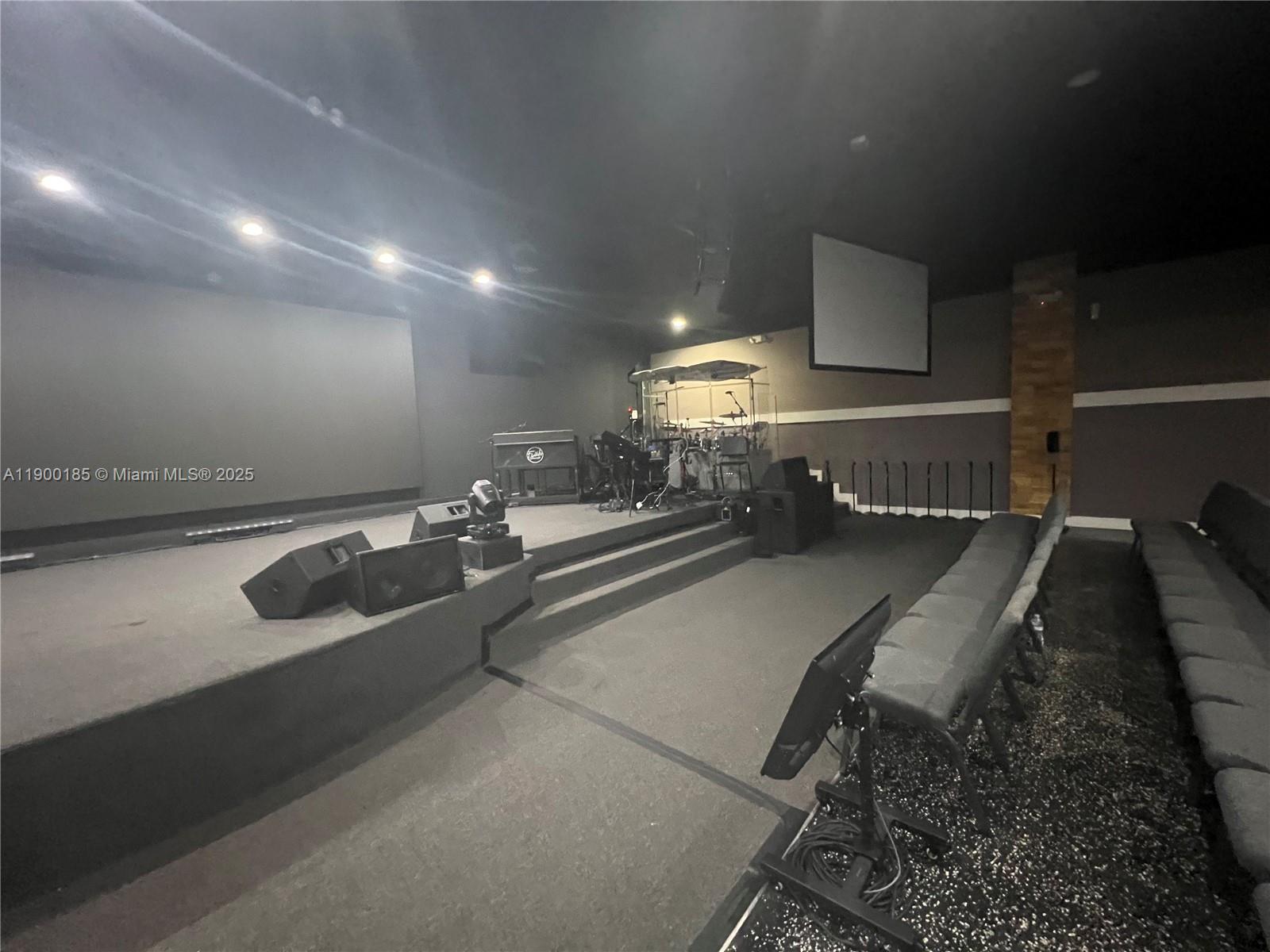 This room features a raised stage with musical equipment, a large screen, and theater-style seating — 3800 N University Dr # 3846, Sunrise FL 33351, SUNRISE, FL