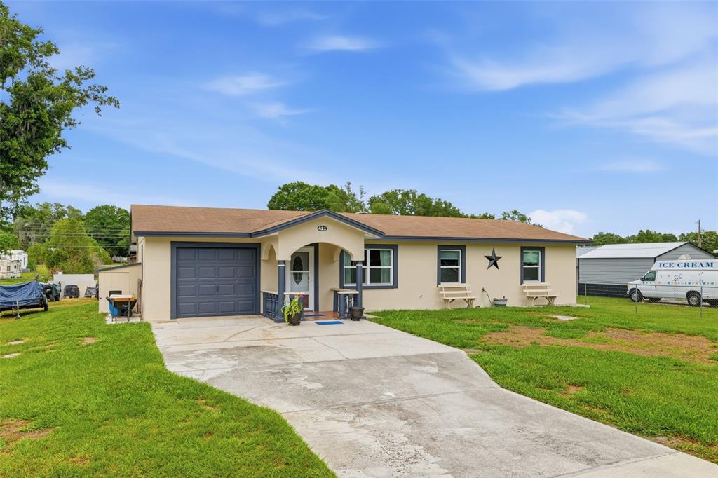 A single-story house with a beige exterior, a front porch, and an attached garage — 421 WATERVIEW DRIVE, POLK CITY, FL