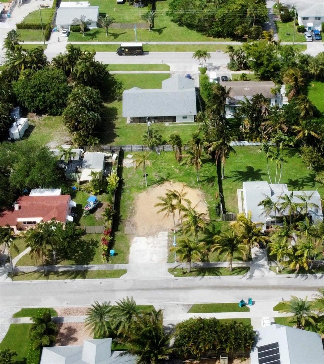 An aerial view shows a vacant residential lot situated between two houses on a street — 647 NE 9th Avenue, Boynton Beach FL 33435, BOYNTON BEACH, FL