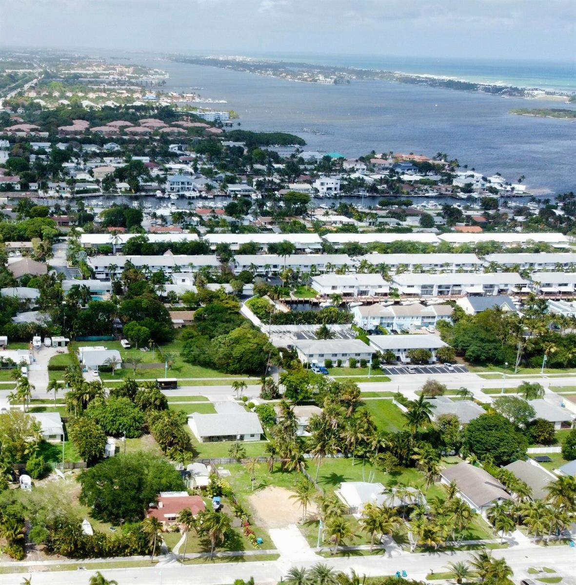 An aerial view of a residential neighborhood featuring houses, apartment complexes, and a nearby waterway — 647 NE 9th Avenue, Boynton Beach FL 33435, BOYNTON BEACH, FL