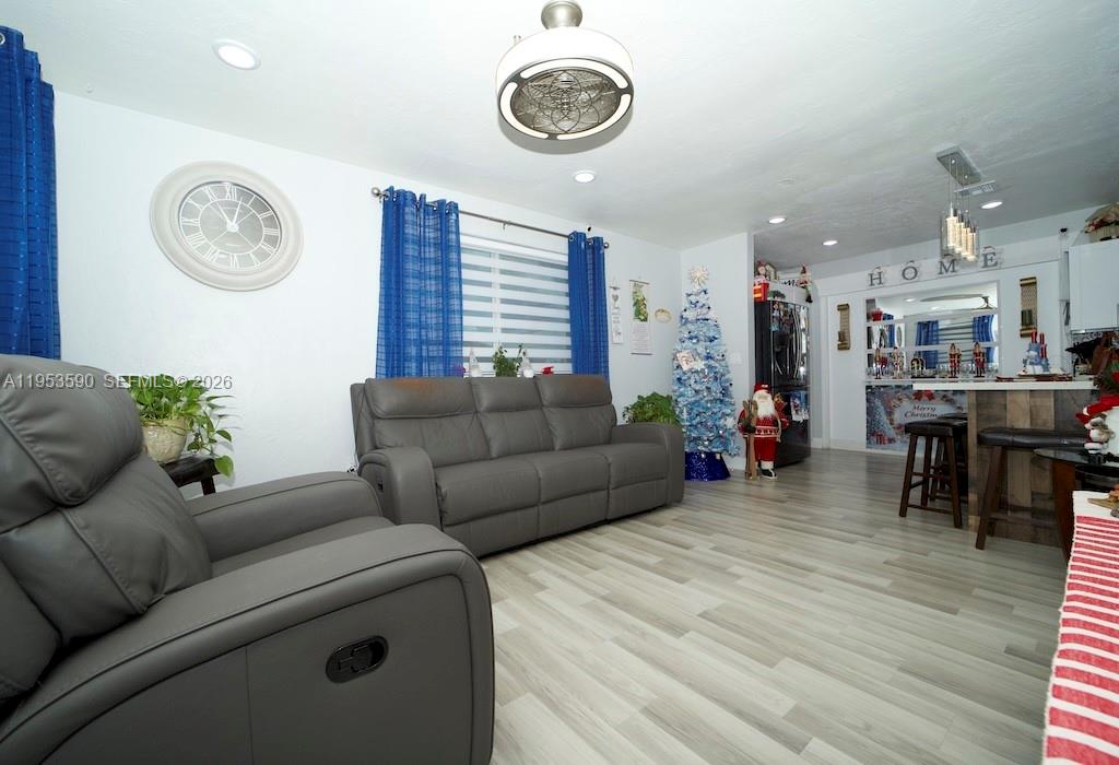 A living room features gray leather furniture, blue curtains, a ceiling fan, and light flooring — 10910 SW 217th Ter, Miami FL 33170, MIAMI, FL