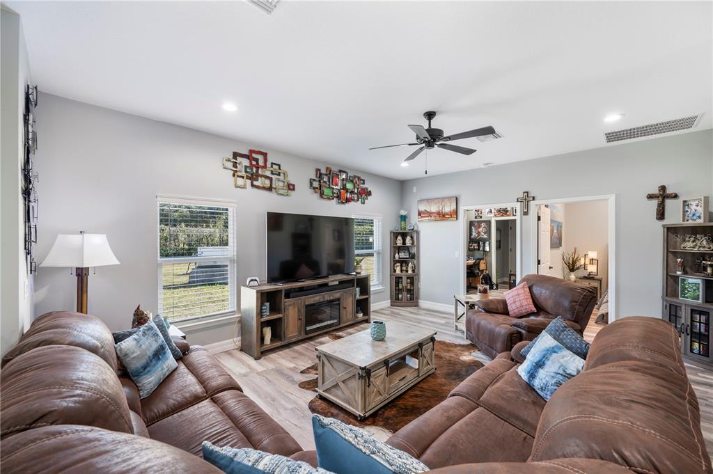 A living room features brown leather sofas, a television console, and a coffee table — 2525 RANCHLAND ACRES ROAD, LAKELAND, FL