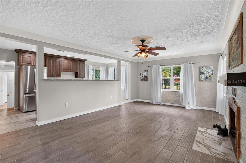 A living room with tile floors, a ceiling fan, and an open kitchen pass-through — 1830 9TH AVENUE W, BRADENTON, FL