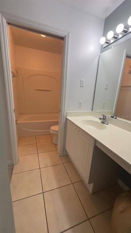 A bathroom features a vanity with a white countertop, a mirror, and a separate tub-shower — 2776 CLUB CORTILE CIRCLE UNIT A, KISSIMMEE, FL