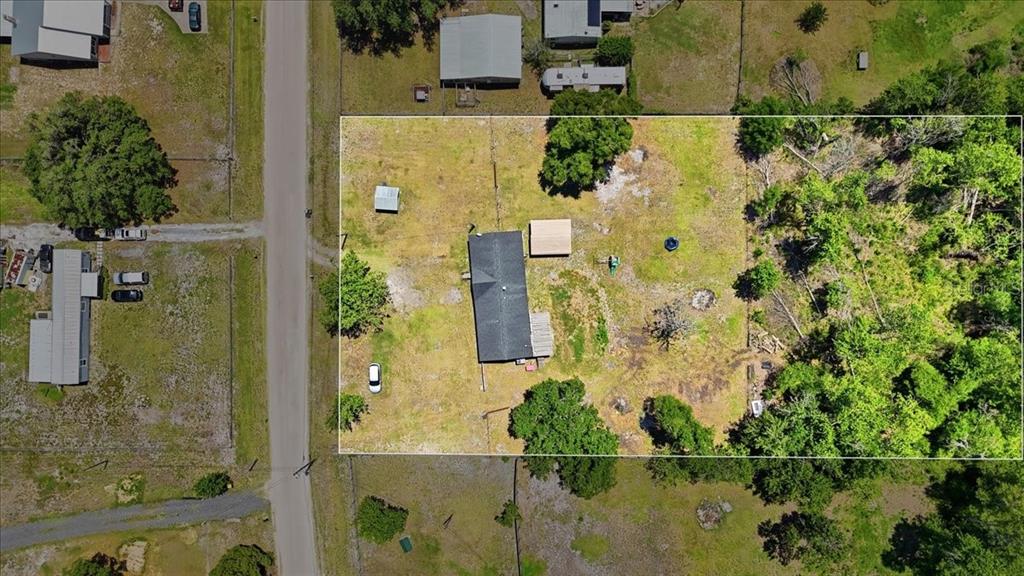 An aerial view shows a rectangular property with a house, outbuildings, and surrounding trees — 10724 PATHFINDER TRAIL, LAKELAND, FL