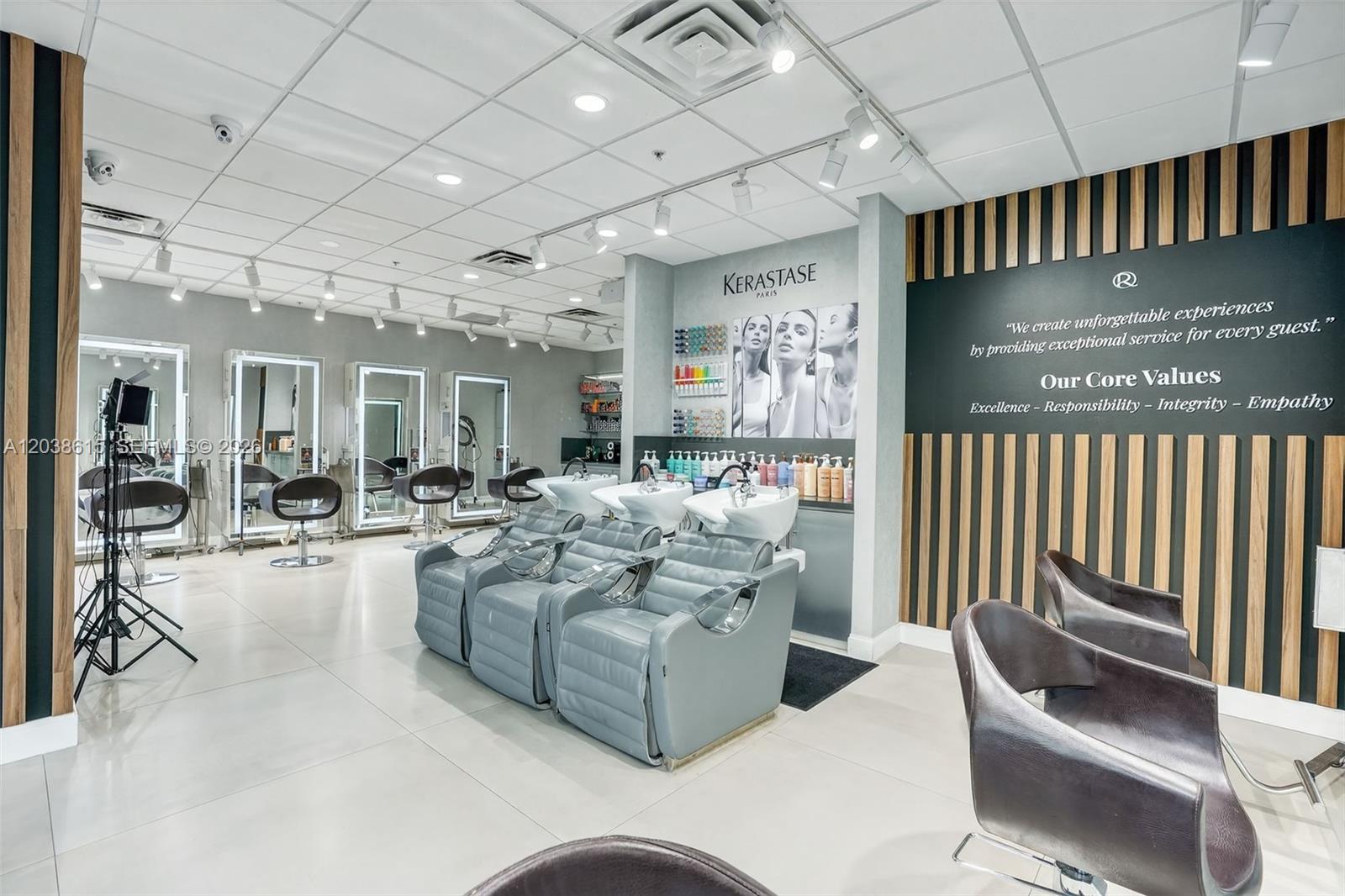 A modern hair salon features multiple styling stations, shampoo chairs, and wood-slatted wall accents — Second Generation Beauty Salon For Lease In Hialeah, FL 33015, FL