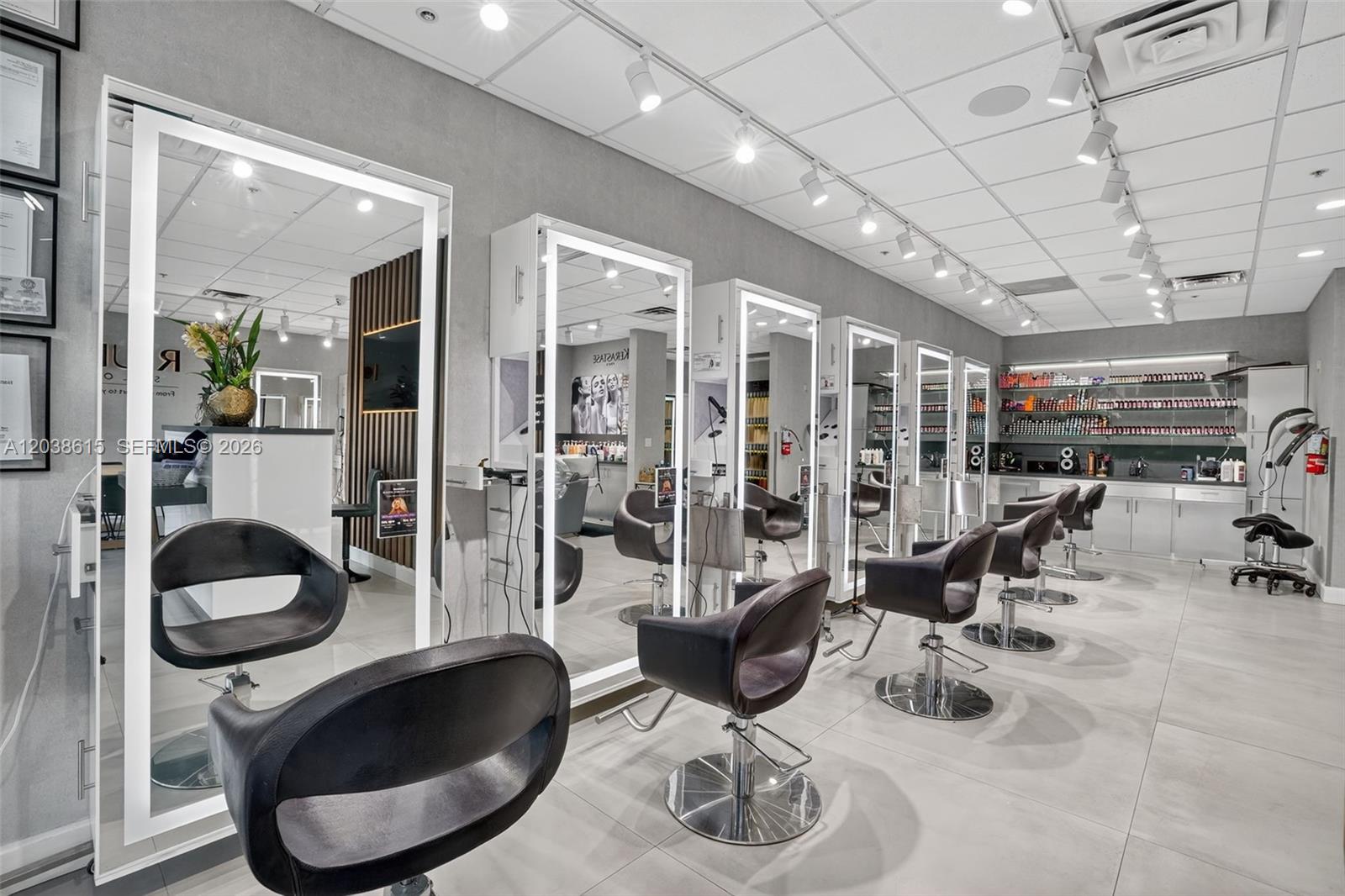 A modern hair salon features multiple styling stations with illuminated mirrors and black leather chairs — Second Generation Beauty Salon For Lease In Hialeah, FL 33015, FL
