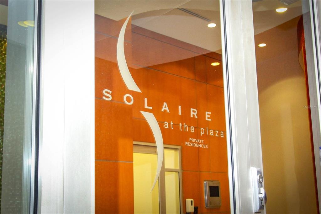 A glass door displays the Solaire at the Plaza logo and text for private residences — 155 S COURT AVENUE UNIT 1102, ORLANDO, FL