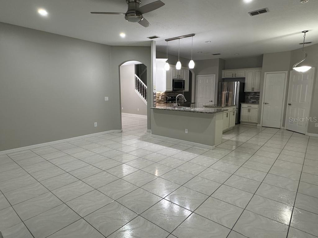 A tiled living area opens to a kitchen with a granite-topped breakfast bar — 4743 CHALFONT DRIVE, ORLANDO, FL