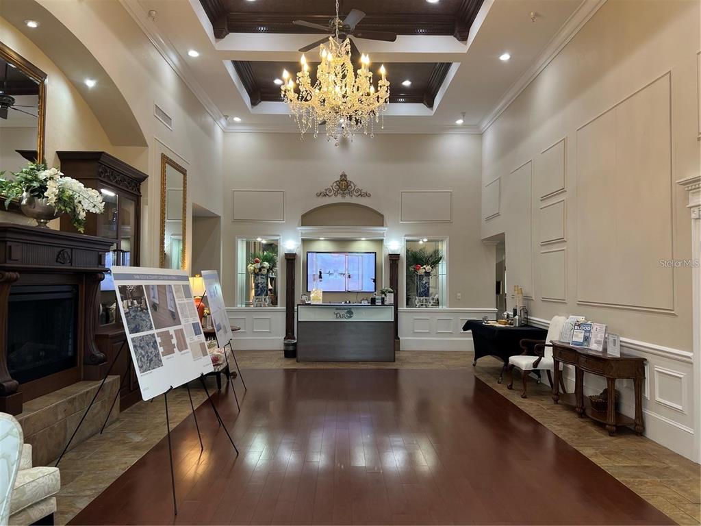 A formal lobby features a crystal chandelier, dark wood flooring, and a central reception desk — 6501 STONE RIVER ROAD UNIT 309, BRADENTON, FL