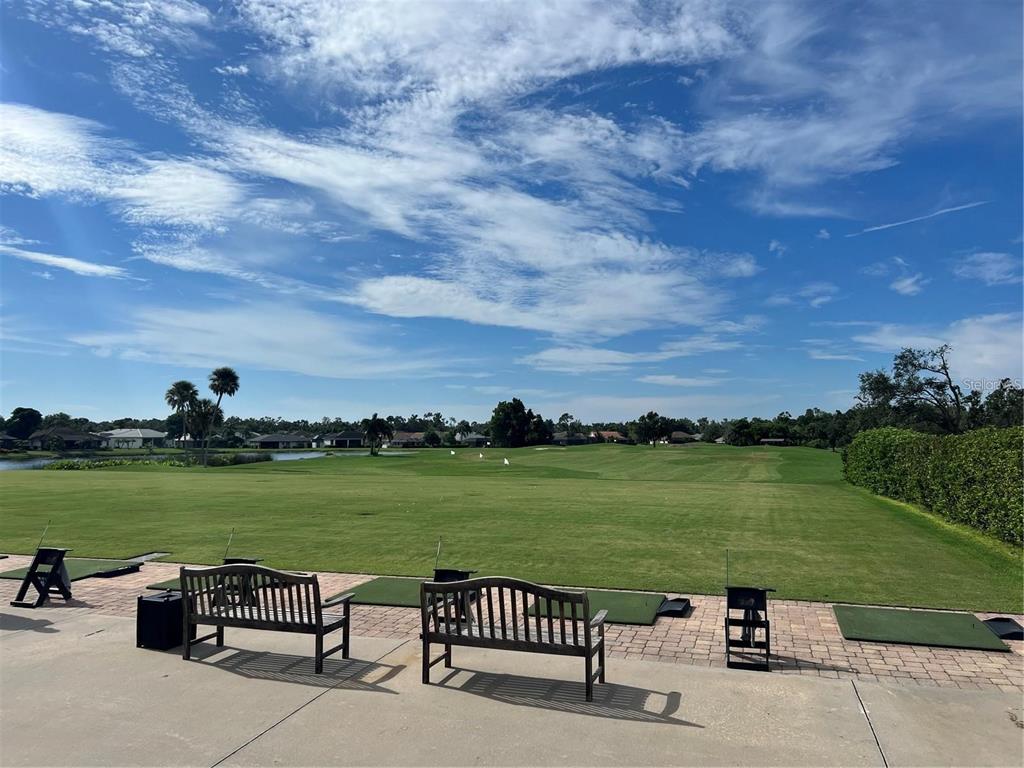 A view of a golf course driving range with benches and practice mats — 6501 STONE RIVER ROAD UNIT 309, BRADENTON, FL