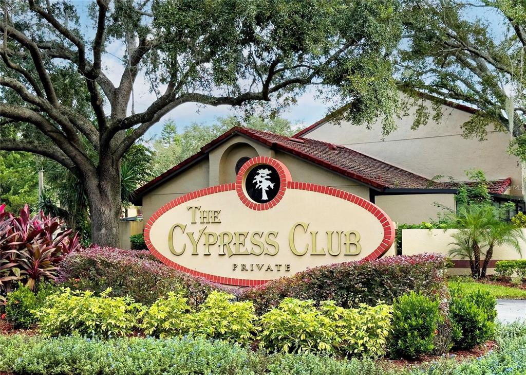An oval sign for The Cypress Club stands in front of a building and trees — 446 CLUB DRIVE, WINTER SPRINGS, FL