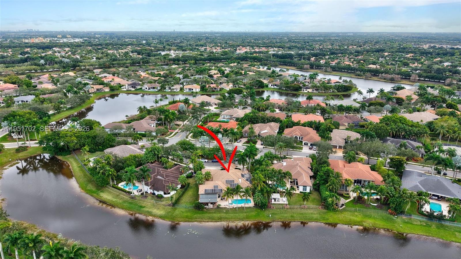 An aerial view shows a residential house with a swimming pool and solar panels — 104 Dockside Cir, Weston FL 33327, WESTON, FL