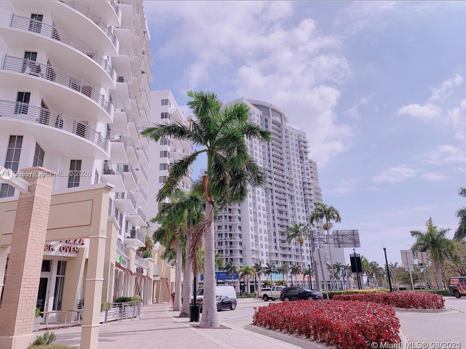 A multi-story residential building exterior with palm trees and a sidewalk in the foreground — 1830 Radius Dr # 1222, Hollywood FL 33020, HOLLYWOOD, FL