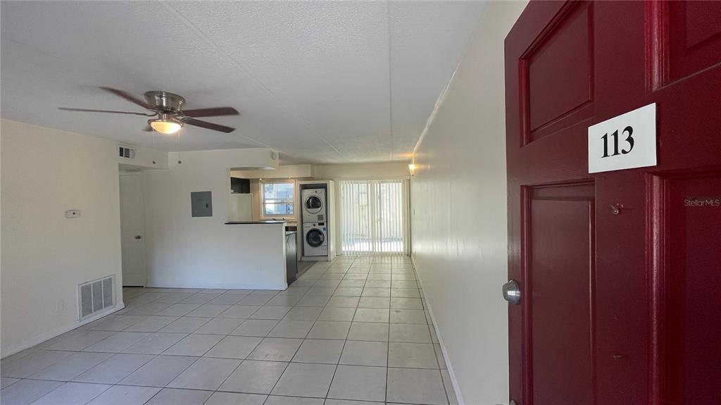 An interior view of an apartment unit featuring tiled floors, a ceiling fan, and laundry — 2800 E 113TH AVENUE UNIT B2113, TAMPA, FL