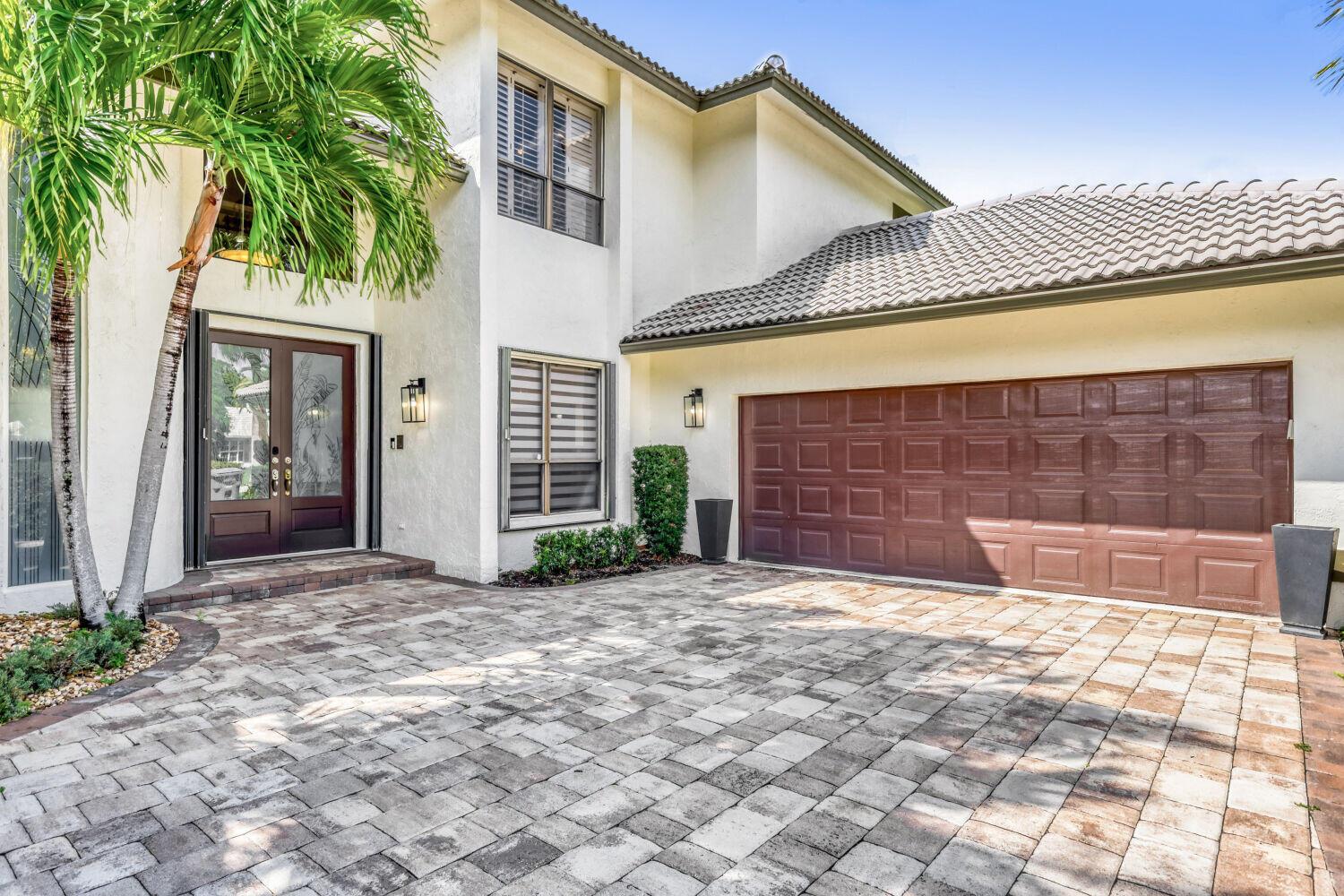 A two-story house exterior features a paved driveway, a brown garage door, and double entry doors — 10273 St Andrews Road, Boynton Beach FL 33436, BOYNTON BEACH, FL