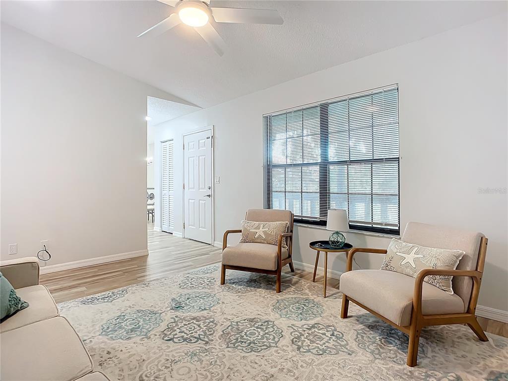A living room features two armchairs, a patterned area rug, and a ceiling fan — 840 CENTER AVENUE UNIT 520, HOLLY HILL, FL