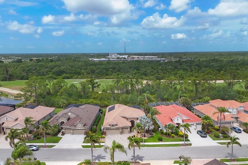 An aerial view of a suburban street with several houses facing a golf course — 1241 CREEK NINE DRIVE, NORTH PORT, FL