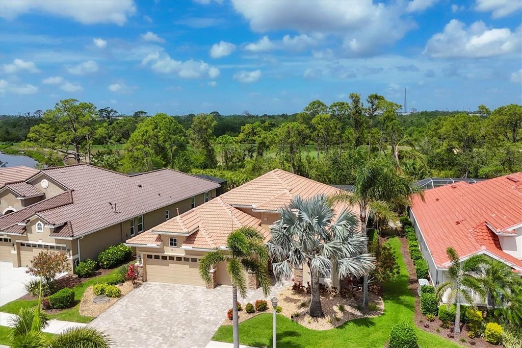 An aerial view shows a suburban house with a tiled roof and a paved driveway — 1241 CREEK NINE DRIVE, NORTH PORT, FL