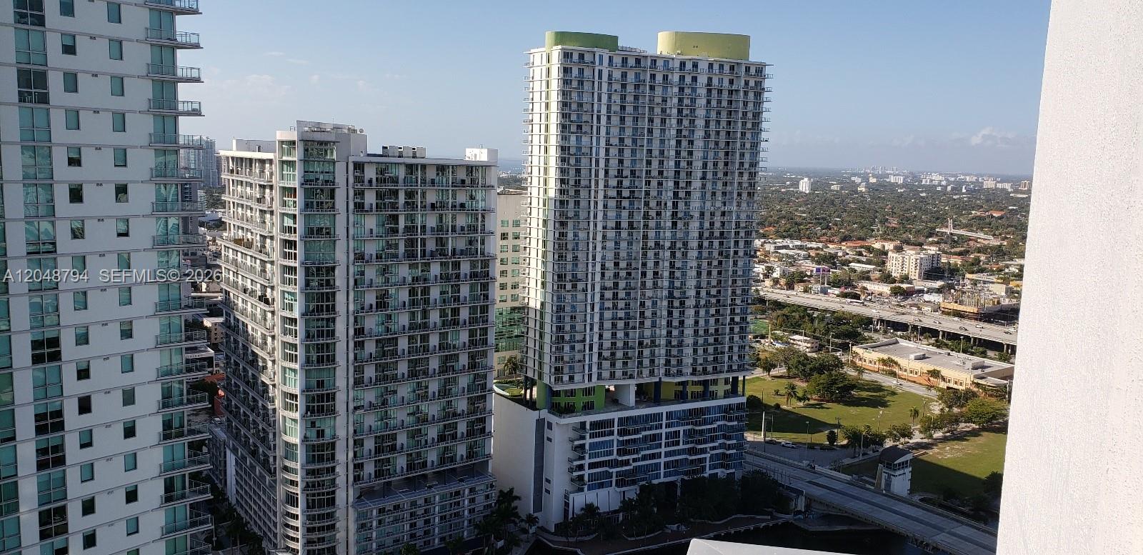 An elevated exterior view shows several tall residential apartment buildings near a highway — 90 SW 3rd St # 3710, Miami FL 33130, MIAMI, FL
