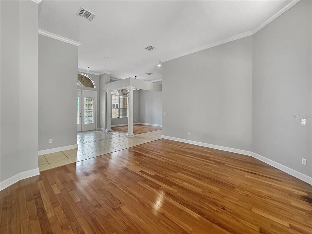 An interior view of a room with hardwood floors, light gray walls, and tiled entryway — 2770 REGAL PINE TRAIL, OVIEDO, FL