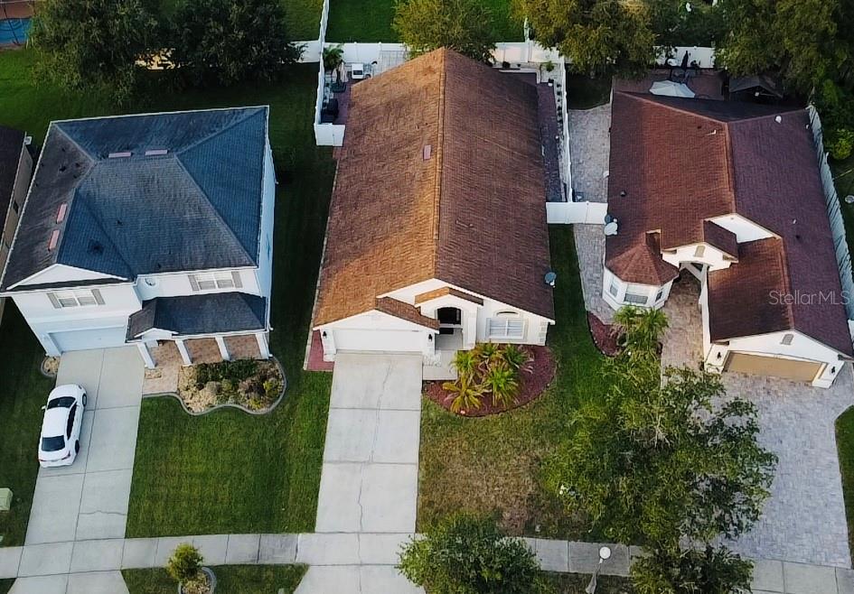 An aerial view shows three suburban houses with driveways, lawns, and shingled roofs — 8885 PALISADES BEACH AVENUE, ORLANDO, FL