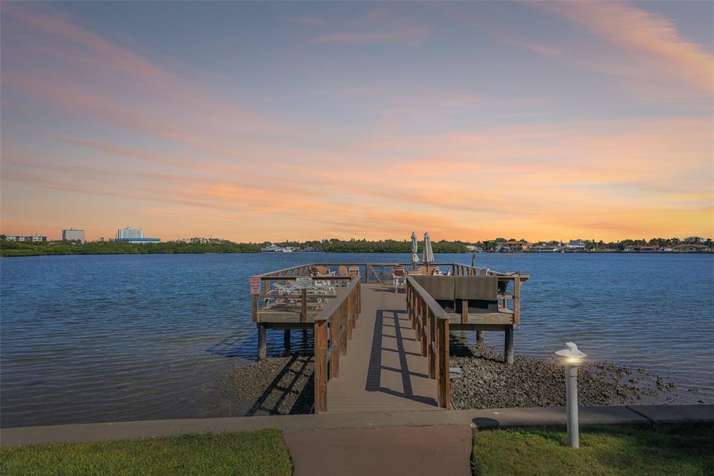 A wooden pier extends into a calm body of water under a sunset sky — 1847 SHORE DRIVE S UNIT 711, SOUTH PASADENA, FL