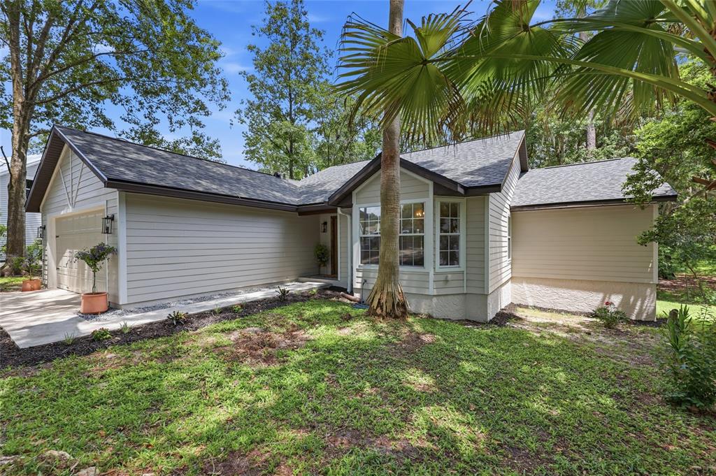 A single-story house with beige horizontal siding, a shingled roof, and a front-facing garage — 3543 NW 84TH WAY, GAINESVILLE, FL