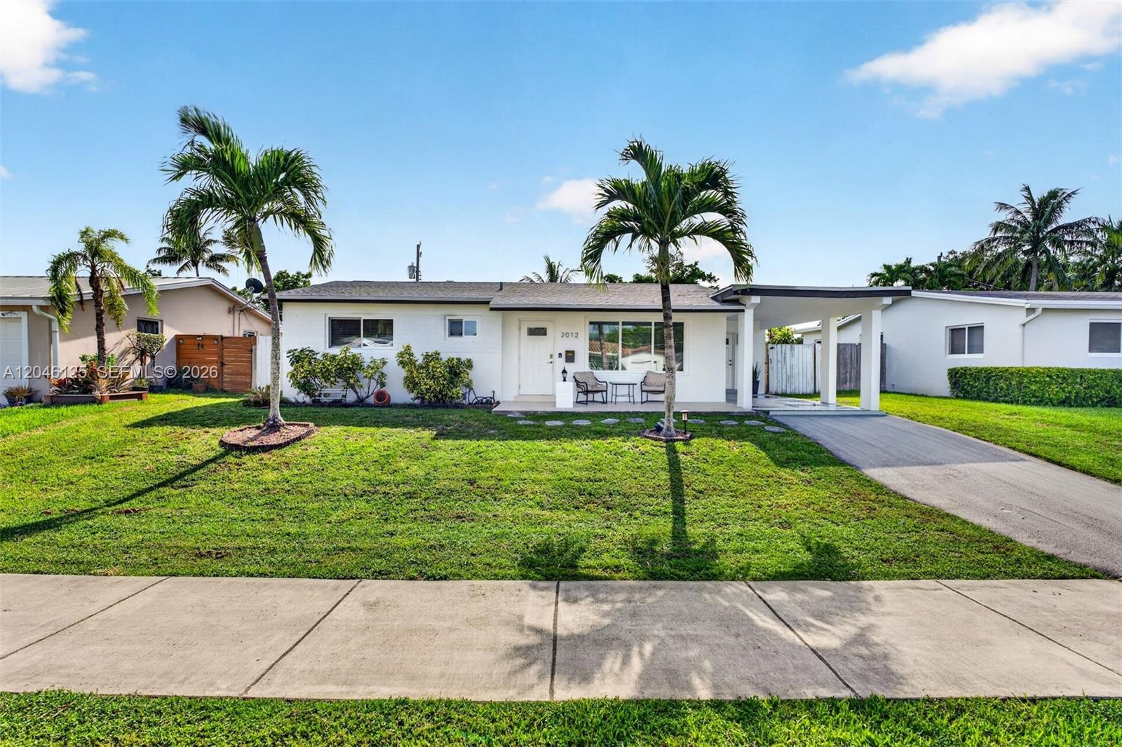 A single-story white house with a front lawn, two palm trees, and a carport — 2012 N 31st Rd, Hollywood FL 33021, HOLLYWOOD, FL