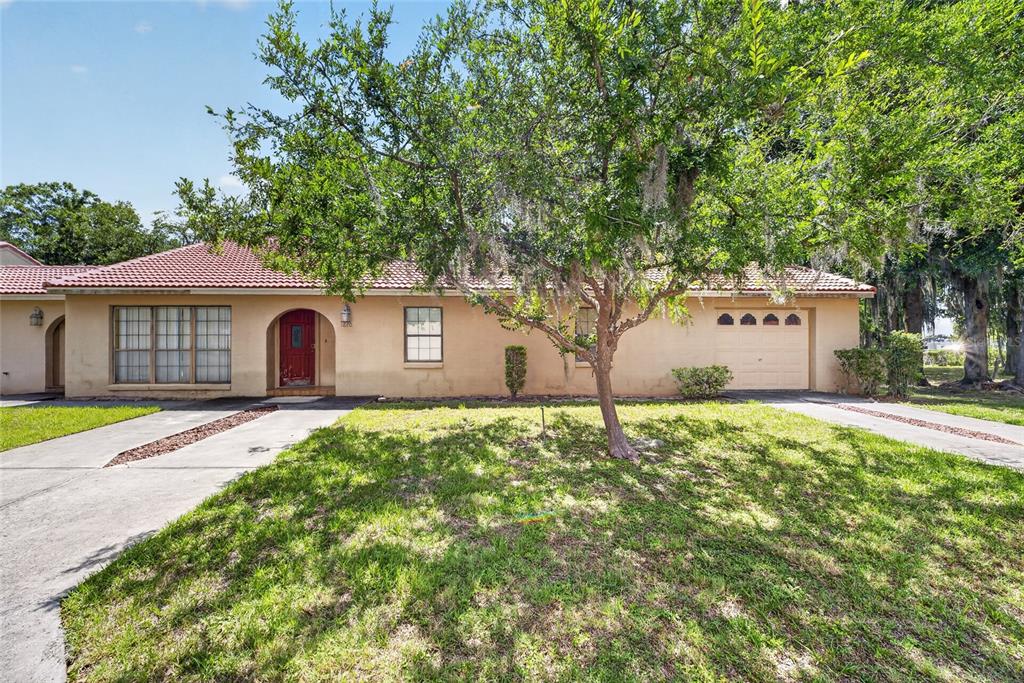 A single-story house with a red tile roof, a red front door, and a garage — 1826 SW 35TH AVENUE, OCALA, FL